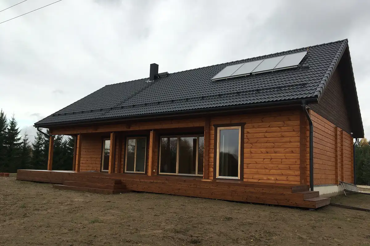 Sangaste palkmaja tumeda plekk-katuse ja päikesepaneelidega